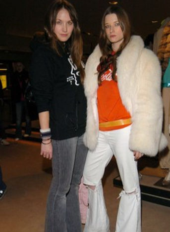 Two women pose in stylish outfits.