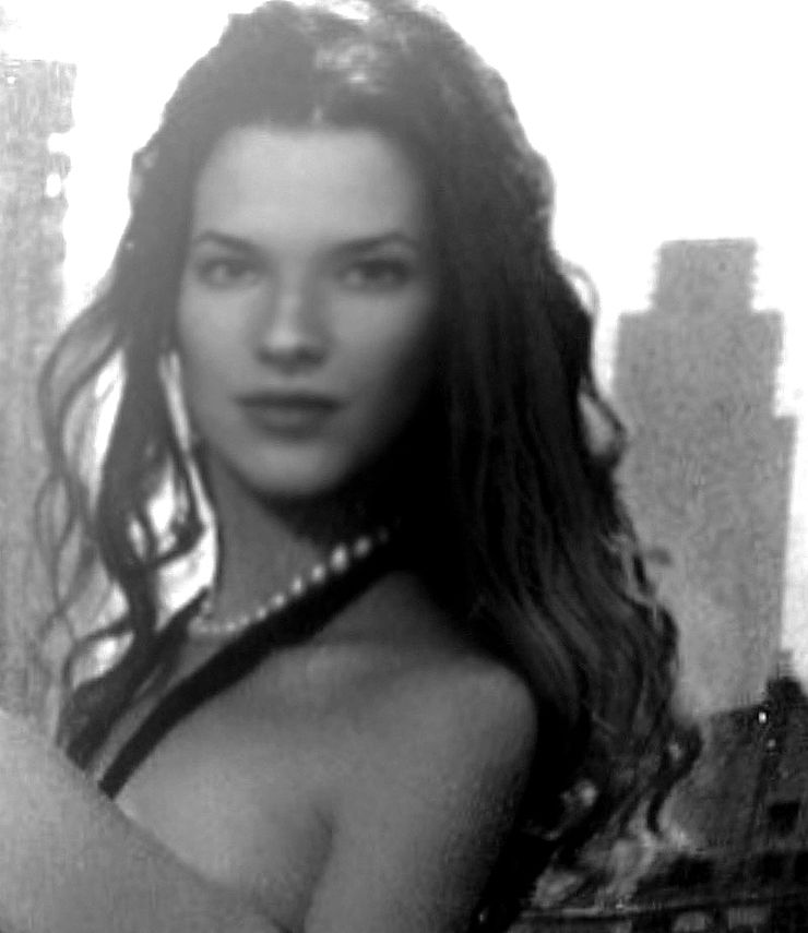 Woman with long hair and pearl necklace poses against urban skyline backdrop.