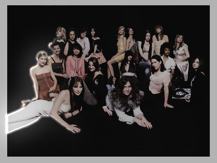 A group of women pose against a dark background, some seated, others standing.